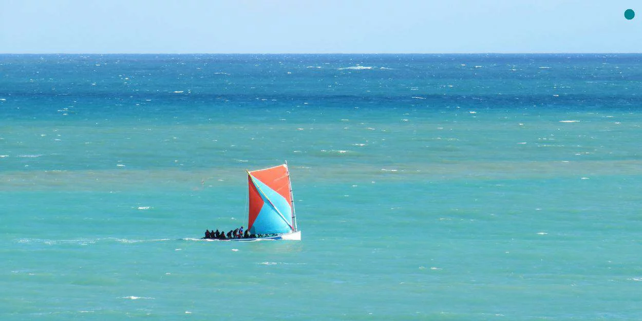 Une yole traditionnelle martiniquaise naviguant sur les eaux turquoise des Caraïbes.